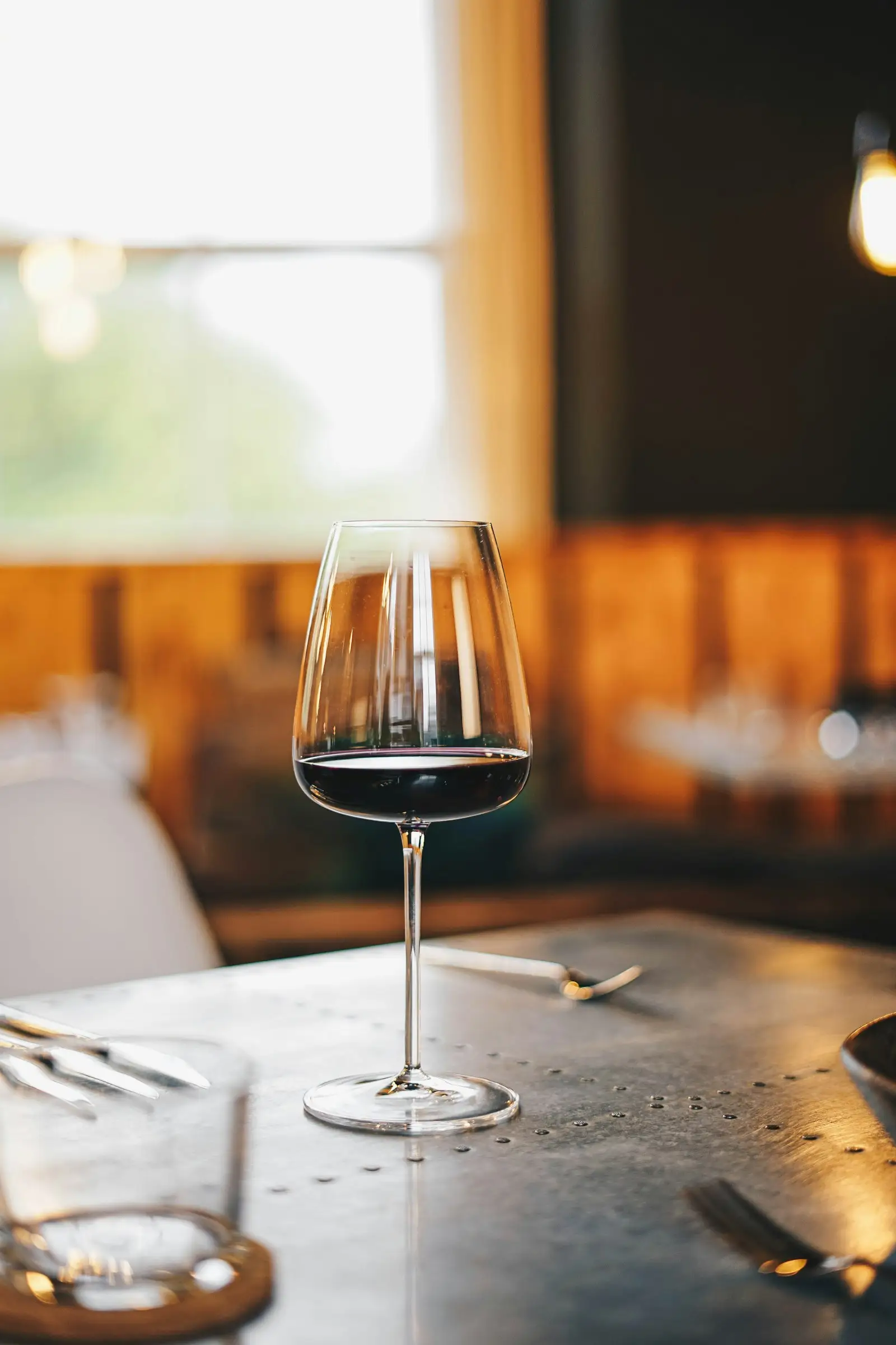 Verre de vin rouge posé sur une table du bistrot